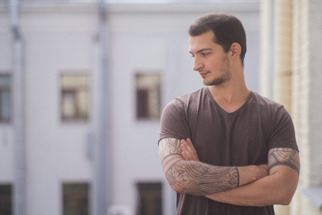 Confident young man standing with arms crossed and smiling